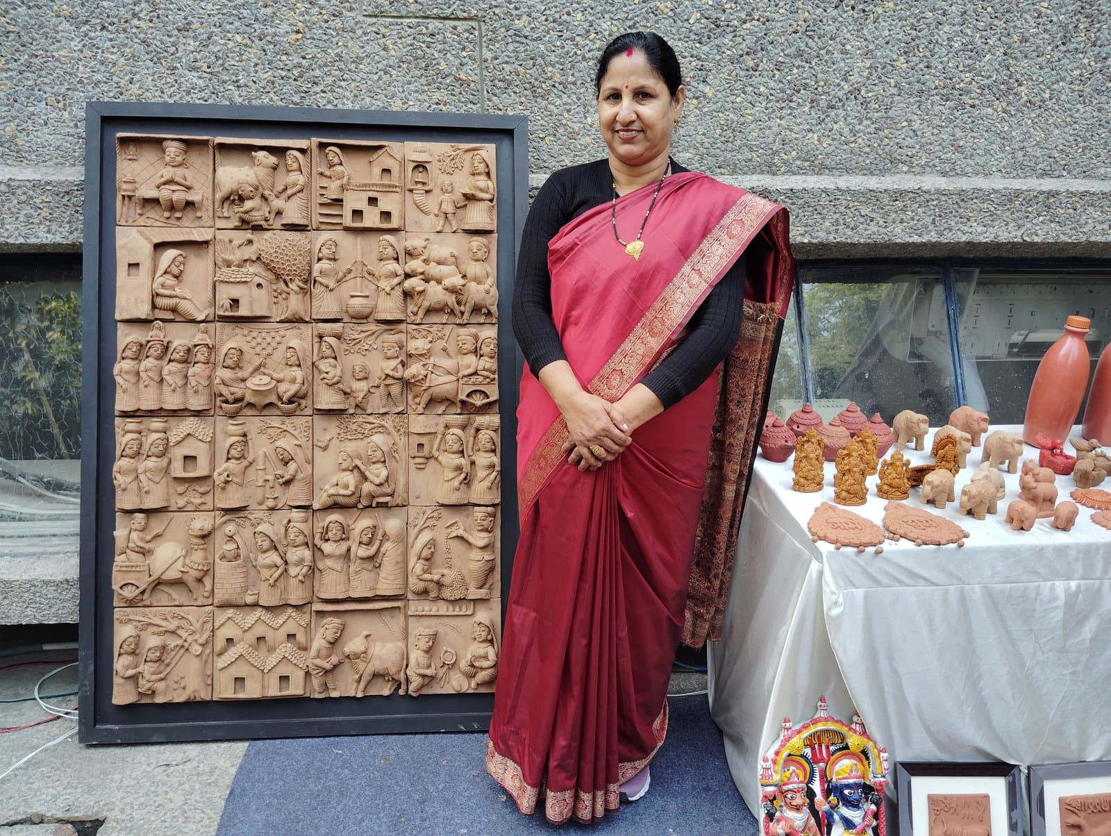 Master artisan Kailash Devi with a monumental multi-tile Indian terracotta mural and clay figurines