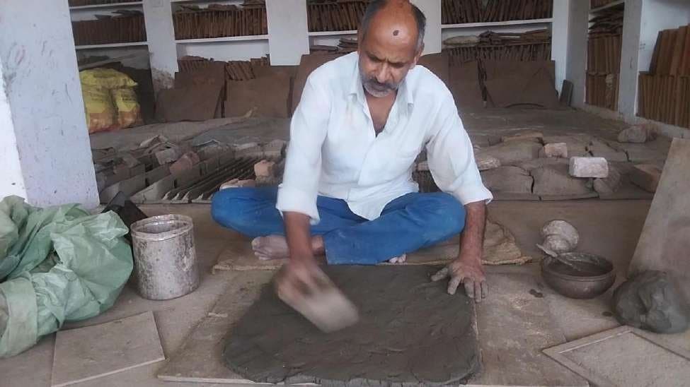 Stage 2: Cutting the flattened terracotta clay slab to an 18x18 inch modular canvas size with wire tools