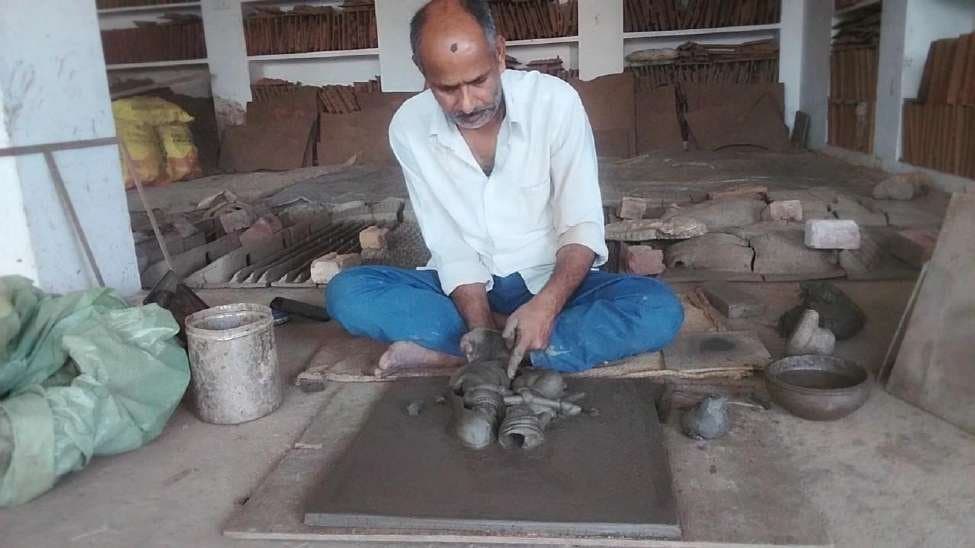Stage 3: Hand-sculpting central portraits of Radha and Krishna in hollow relief on the clay slab