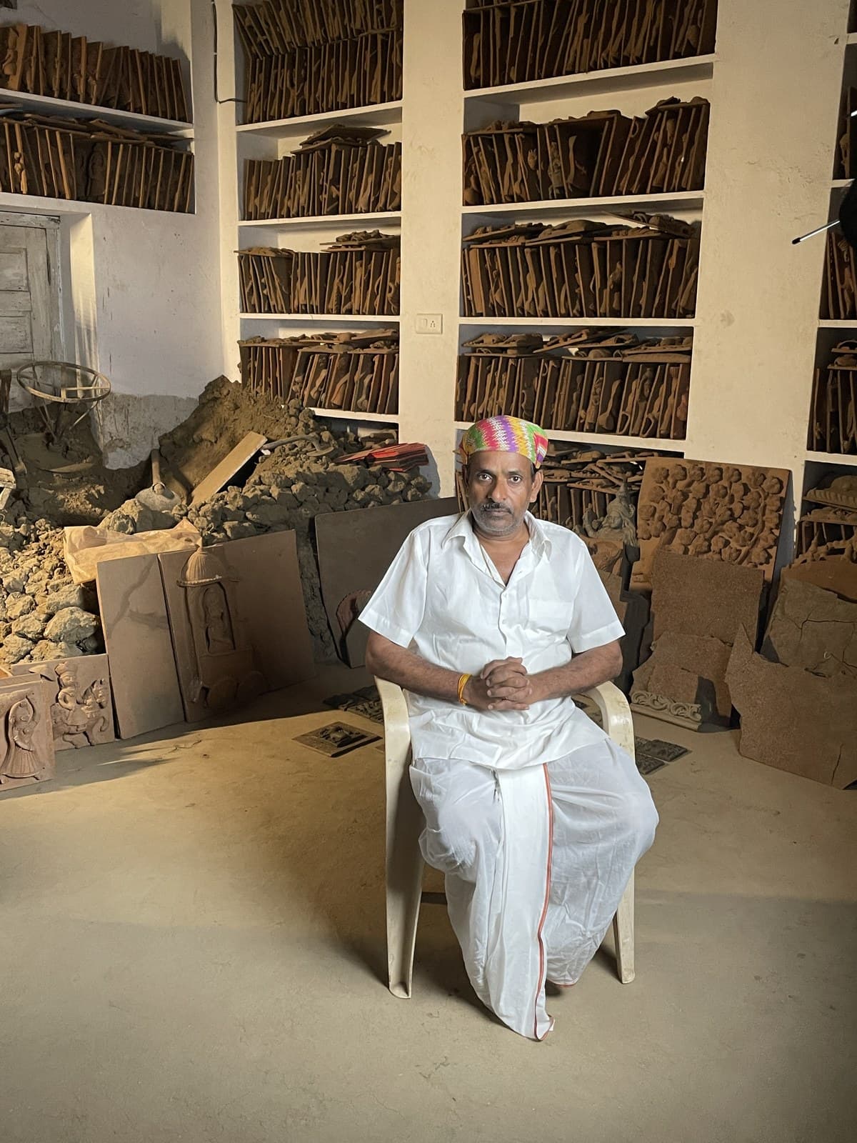 Dinesh Chandra Kumhar hand-sculpting traditional clay relief plaques in the studio