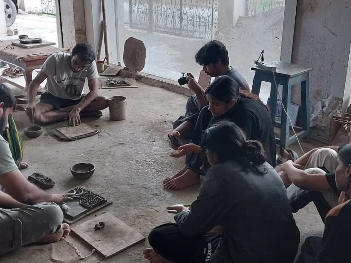 Mohit Kumhar mentoring and documenting during a hands-on Molela terracotta sculpting workshop in the studio